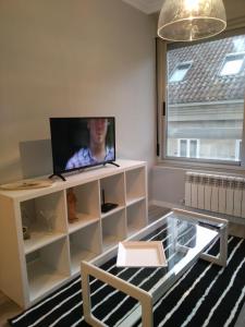un salon avec une télévision à écran plat sur un meuble blanc dans l'établissement Torre Center, à Saint-Jacques-de-Compostelle