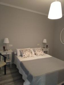 um quarto com uma cama e duas mesas e um candeeiro em Torre Center em Santiago de Compostela