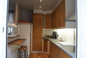 a small kitchen with wooden cabinets and a counter top at Clos Normand in De Panne