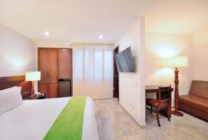a hotel room with a bed and a couch and a television at Hotel Palonegro in Bucaramanga