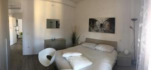 a white bedroom with a bed and a table at Appartamenti Giada in Verona