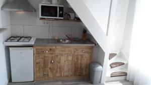 eine kleine Küche mit einer Spüle und einer Mikrowelle in der Unterkunft Appartement vlakbij strand en centrum in Zoutelande