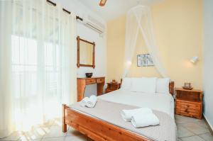 a bedroom with a bed with towels on it at Skarmoutsos Studios in Aliko Beach