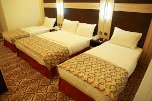 a hotel room with two beds and two tables at Deema Hotel in Dubai +21 photos