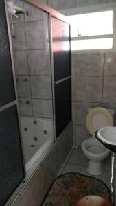 a bathroom with a shower and a toilet and a sink at Hotel Pousada Por do Sol in Protásio Alves