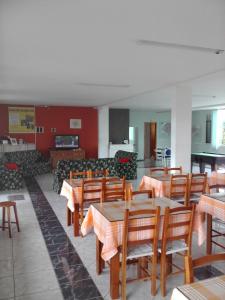 a restaurant with tables and chairs and a couch at Hotel Pousada Por do Sol in Protásio Alves
