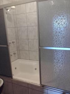 a shower with a glass door in a bathroom at Hotel Pousada Por do Sol in Protásio Alves