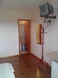 a bedroom with a tv on a tripod in a room at Hotel Pousada Por do Sol in Protásio Alves