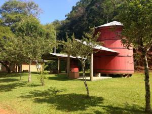 a red building with trees in front of it at Hotel Pousada Por do Sol in Protásio Alves