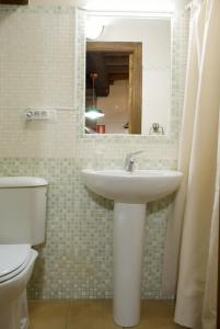 a bathroom with a sink and a toilet and a mirror at A Lareira De Allariz in Allariz +13 photos