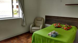 un dormitorio con una mesa verde con un animal de peluche. en Luiz & Cristiana Sampaio, en Salvador
