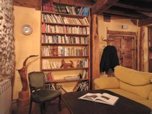 sala de estar con sofá y estantería con libros en Casa Rural de la Villa, en Calatañazor