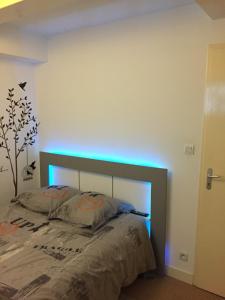 1 dormitorio con 1 cama con luz azul en Appartement T3 en souplex sur le port de Saint Goustan, en Auray