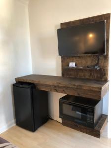 a living room with a table with a microwave and a television at Mayflower Motel in Kitchener