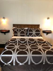 1 dormitorio con 1 cama grande y 2 mesitas de noche en Mayflower Motel, en Kitchener