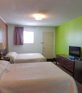 Habitación de hotel con 2 camas y TV de pantalla plana. en Elk Point Motel & RV Park, en Elk Point