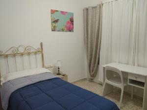 アンテケラにあるApartamento Alameda de Andalucía de Antequeraのベッドルーム1室(青いベッド1台、デスク、テーブル付)