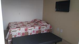 a small bedroom with a bed and a bench at Recanto do Valtinho in Florianópolis