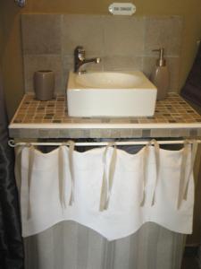 a bathroom counter with a sink and white towels at au balcon du bonheur in Malandry