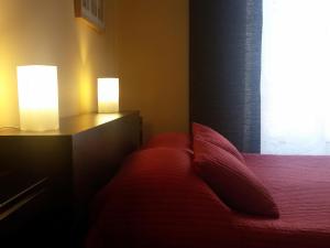 a bedroom with a red bed with two lamps on it at Alma Clara B&B in Turin