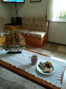 a coffee table with a model ship and a plate of bread at Drosia Hotel in Georgioupolis