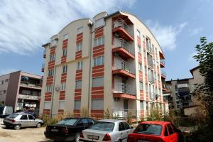 a tall building with cars parked in front of it at Central DeLuxe Apartments Ohrid in Ohrid