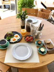 a wooden table with plates of breakfast food on it at Nival Luxury Suites in Chania Town