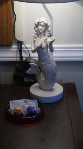 Una statua di una sirena seduta su un tavolo di Mermaid Inn a Long Beach