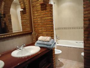 a bathroom with a sink and a toilet and a tub at Casa Bodega Vacacional in Sajazarra