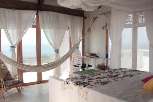 a bedroom with a hammock bed and large windows at Frente al Mar in Santa Verónica