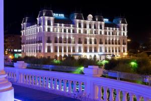 a large white building with lights on it at night at Gran Hotel Sardinero in Santander