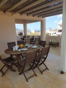 a wooden table and chairs on a patio at Rastoni Apartments in Kissamos