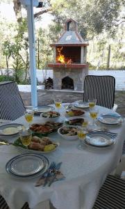 una mesa con platos de comida y una chimenea en Villa Valia, en Skala Kallirakhis
