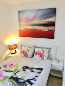 een slaapkamer met een bed met roze bloemen erop bij Barcaresa-Agréable appartement vue mer panoramique in Le Barcarès
