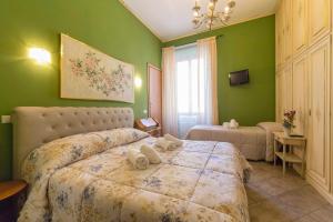 a bedroom with green walls and a bed with towels on it at Albachiara Guest House in Rome +33 photos