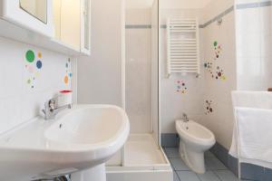 a white bathroom with a sink and a toilet at Albachiara Guest House in Rome