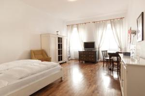 - une chambre avec un lit, un bureau et une table dans l'établissement Residence Fink Central Apartments, à Bolzano