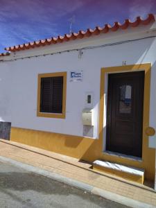 ein weißes und gelbes Gebäude mit einer Tür in der Unterkunft Estevas de Monsaraz in Monsaraz