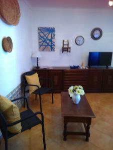 ein Wohnzimmer mit einem Tisch und Stühlen sowie einem TV in der Unterkunft Estevas de Monsaraz in Monsaraz