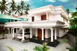 a white house with a car in front of it at Luxury Villas of Guruvayur in Guruvāyūr