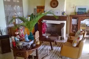a living room with a table and a fireplace at Casa Vista Para o Mar in Ilhabela
