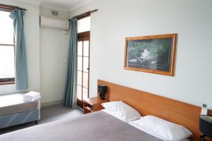 Postel nebo postele na pokoji v ubytování Hurstville Ritz Hotel