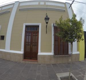 una casa amarilla con una puerta marrón y una ventana en Apartamento Siria en Salta