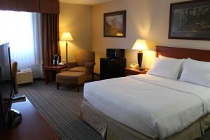 a hotel room with a large bed and a chair at 3 Rivers Hotel in Bozeman