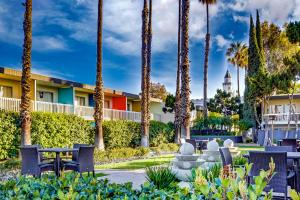 un parque con palmeras y sillas y un edificio en Anaheim Hotel en Anaheim