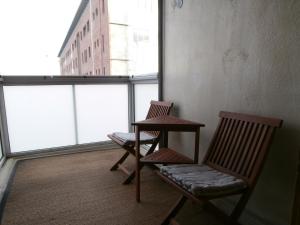 Dos sillas y una mesa en una habitación con ventana. en Huoneistohotelli Nallisuites, en Oulu