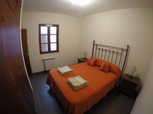 1 dormitorio con cama con sábanas de color naranja y ventana en Apartamento Siria en Salta