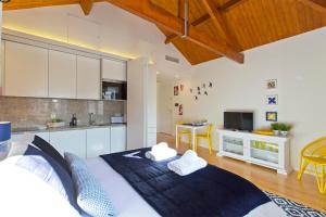 a bedroom with a large bed and a kitchen at Ribeira Stay Apartments in Porto
