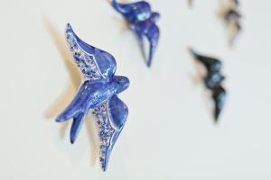 a group of blue glass birds on a wall at Ribeira Stay Apartments in Porto