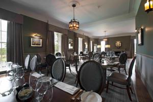 a dining room with tables and chairs in a restaurant at Meldrum House Hotel Golf And Country Estate in Oldmeldrum